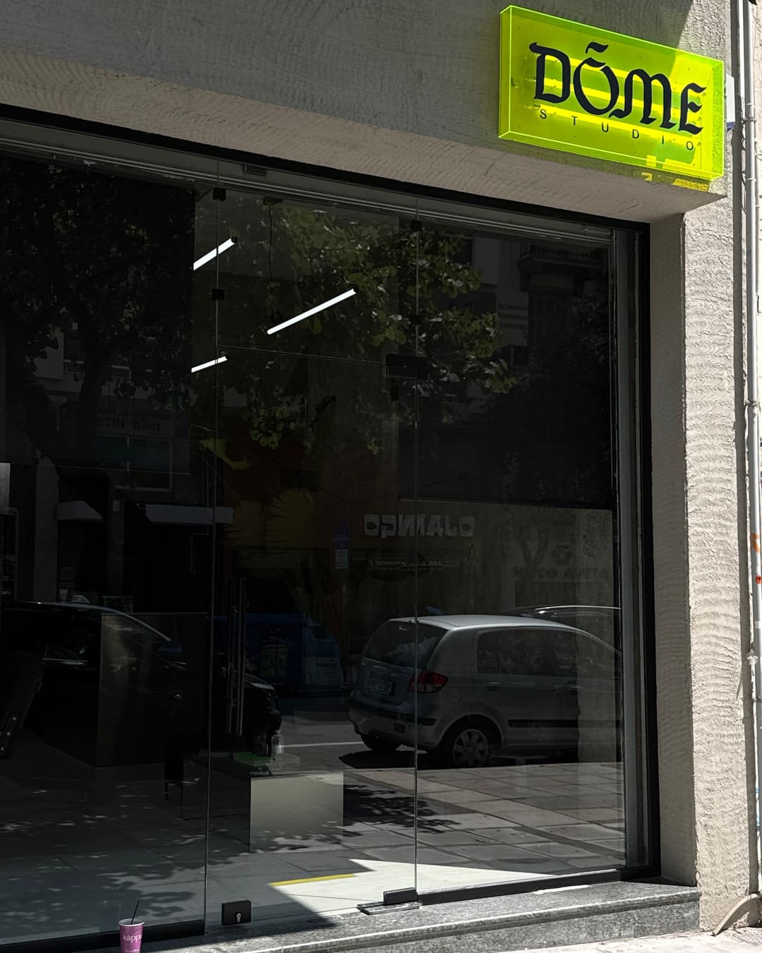 Η πρόσοψη του στούντιο με την πινακίδα DŌME STUDIO πάνω από τη τζαμαρία